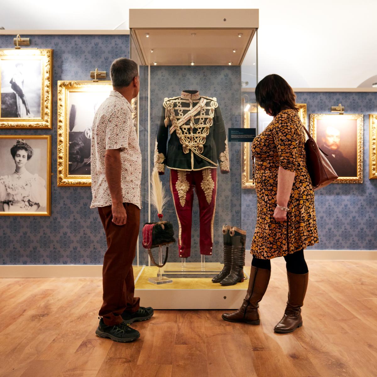 Visitors looking at a military uniform displayed in a case in the Churchill exhibition