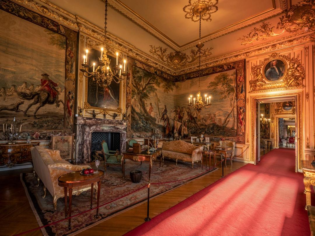 A State Room hung with tapestries, with a marble fireplace and gilded furniture