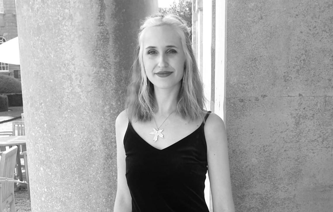 Singer Amelia Grech standing beside a stone column at Blenheim Palace