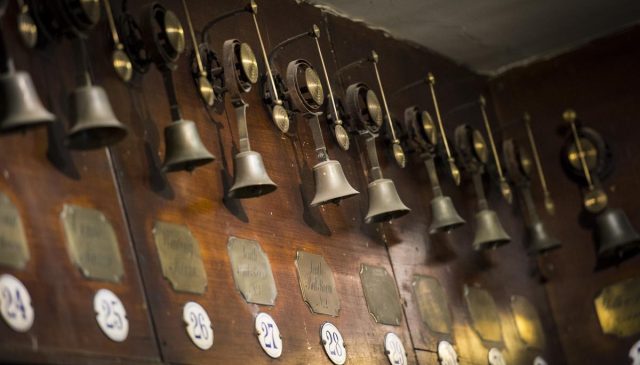The servants' bell board, with rows of numbered brass bells above engraved room labels