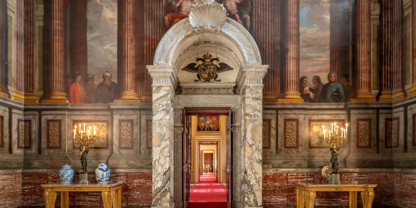 The marble doorcase and painted walls of the Saloon, looking through to the State Rooms beyond