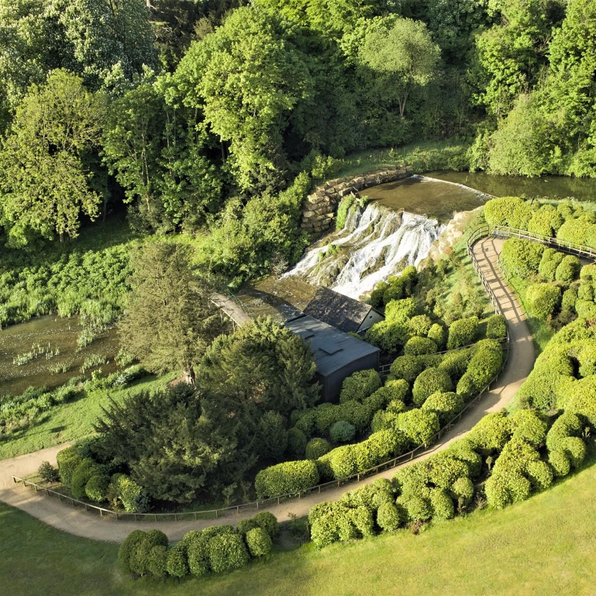 The Grand Cascade falling from the lake, with a winding path and clipped shrubs above it