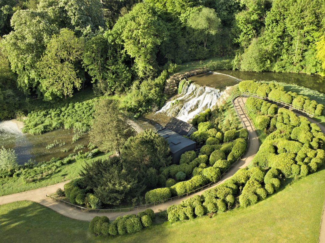 The Grand Cascade falling from the lake, with a winding path and clipped shrubs above it
