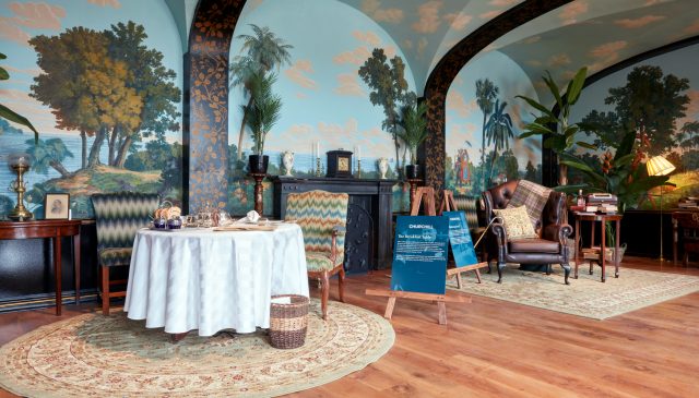 A table laid for breakfast in a mural-painted room in the Churchill exhibition at Blenheim Palace