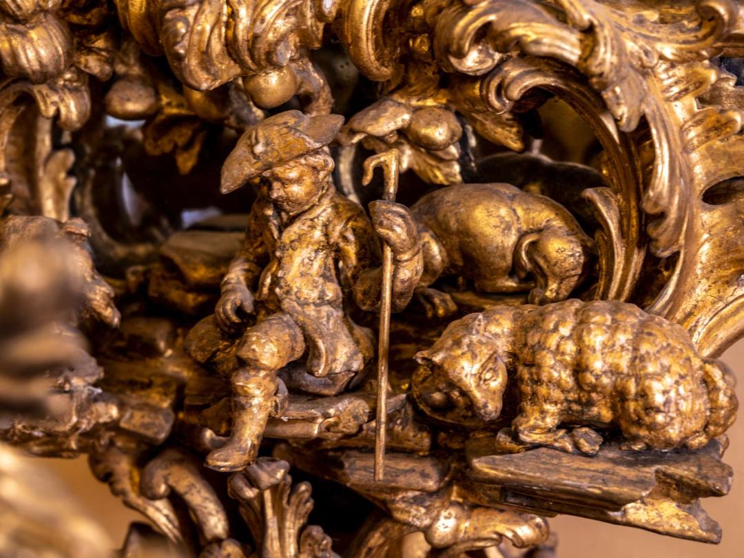 A detail of gilded carving showing a shepherd with his sheep