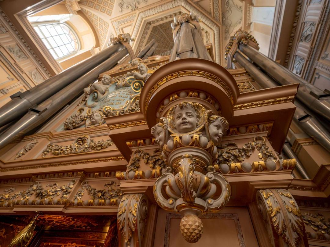 Carved cherubs and gilding on the case of the Willis organ, with its pipes above