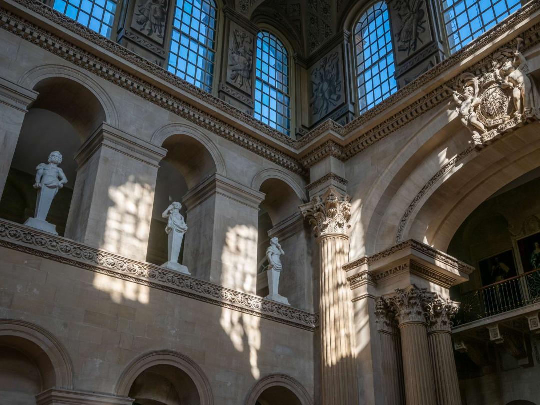 Statues in niches and clerestory windows high in the Great Hall, beside a carved coat of arms