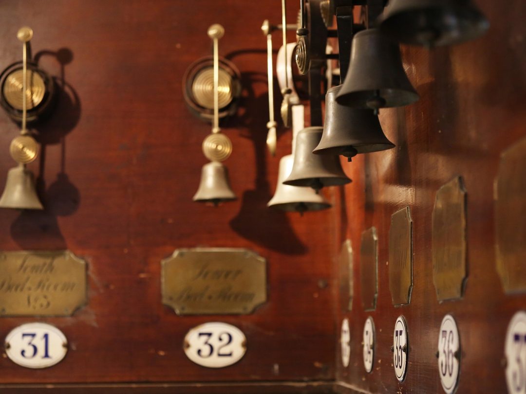 A close view of the servants' bell board, with numbered bells and engraved room labels