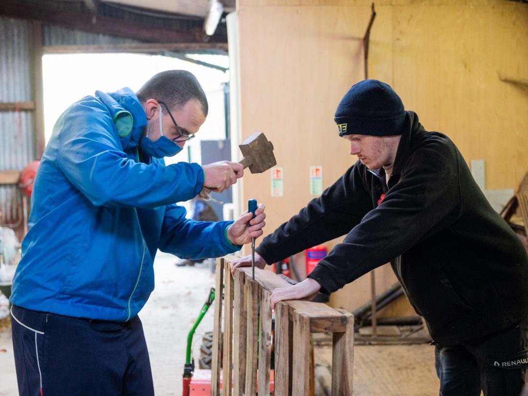 Co farmers Jamie, left, and volunteer Will ,right, help break down pallets at Blenheim Estate’s workshop