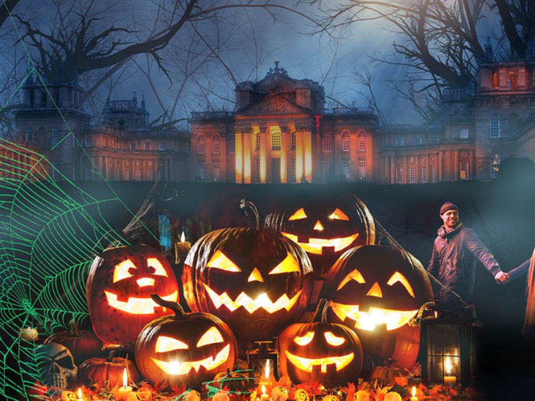 Carved pumpkins glowing in front of the Palace lit up at night for Halloween