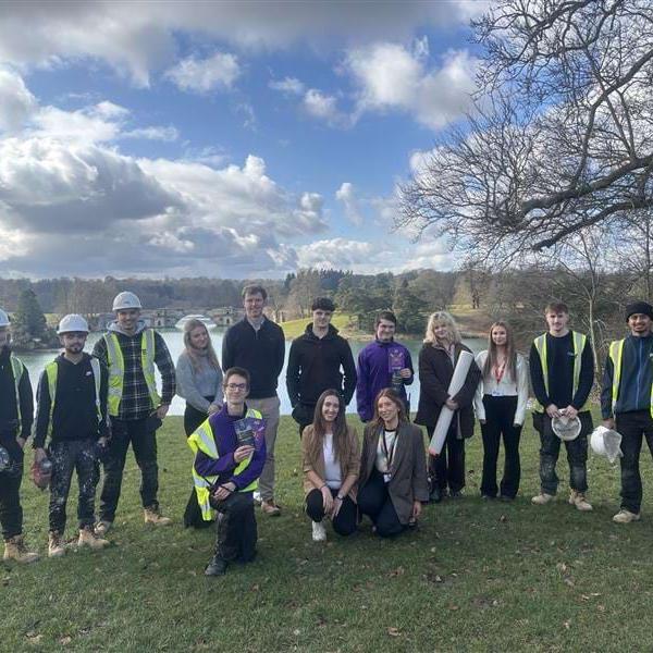 Apprentices and colleagues gathered in a group beside the lake
