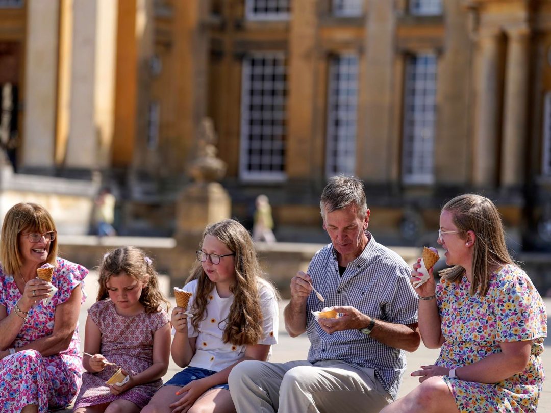 A family eating ice creams in the sunshine outside the Palace