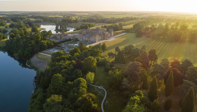 Aerial view at golden hour of the Palace, the lake and surrounding parkland and woods