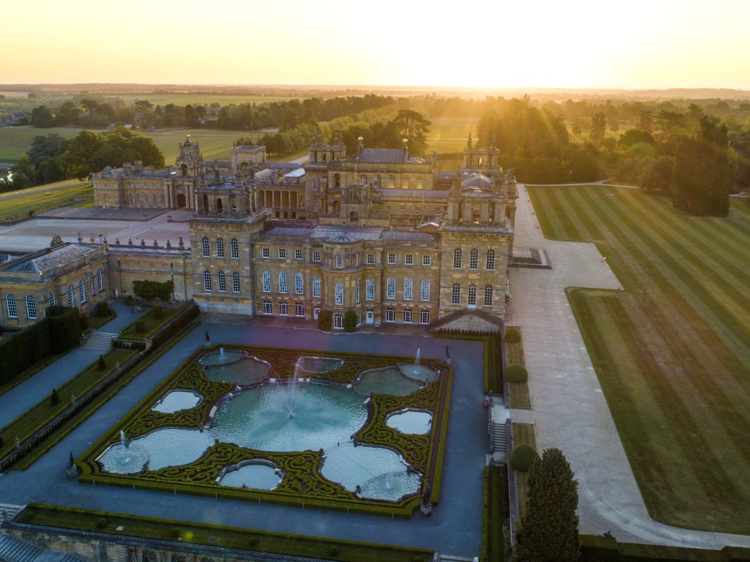 Blenheim Palace and the Water Terraces from the air at sunset, with the fountains playing