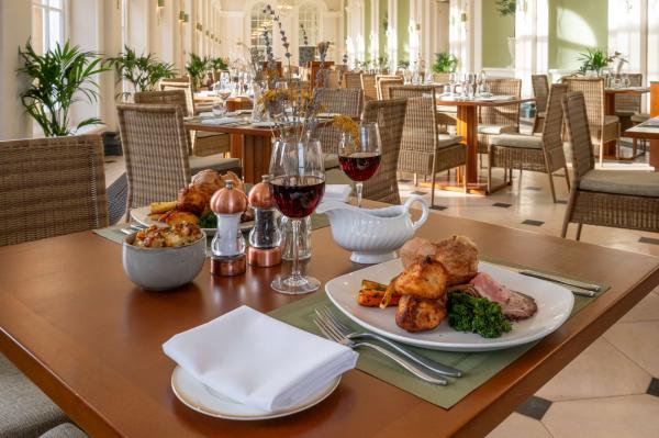 A roast lunch served with red wine at a table in the Orangery restaurant