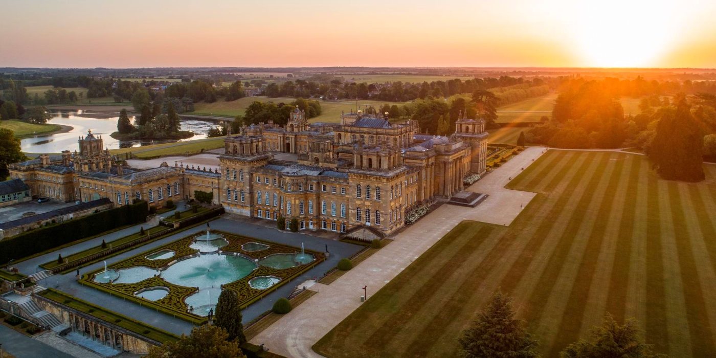 Blenheim Palace and its Water Terraces from the air at sunset, with the lake beyond