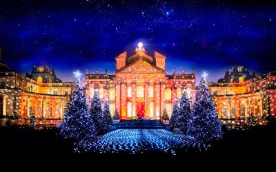 The Palace lit red and gold at night, with sparkling Christmas trees and lights across the Great Court