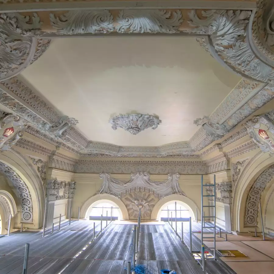 The Chapel under restoration, with ornate white plasterwork on the ceiling and scaffolding below
